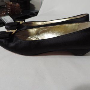 Women's black Ferragamo pumps with decorative bow on toe.